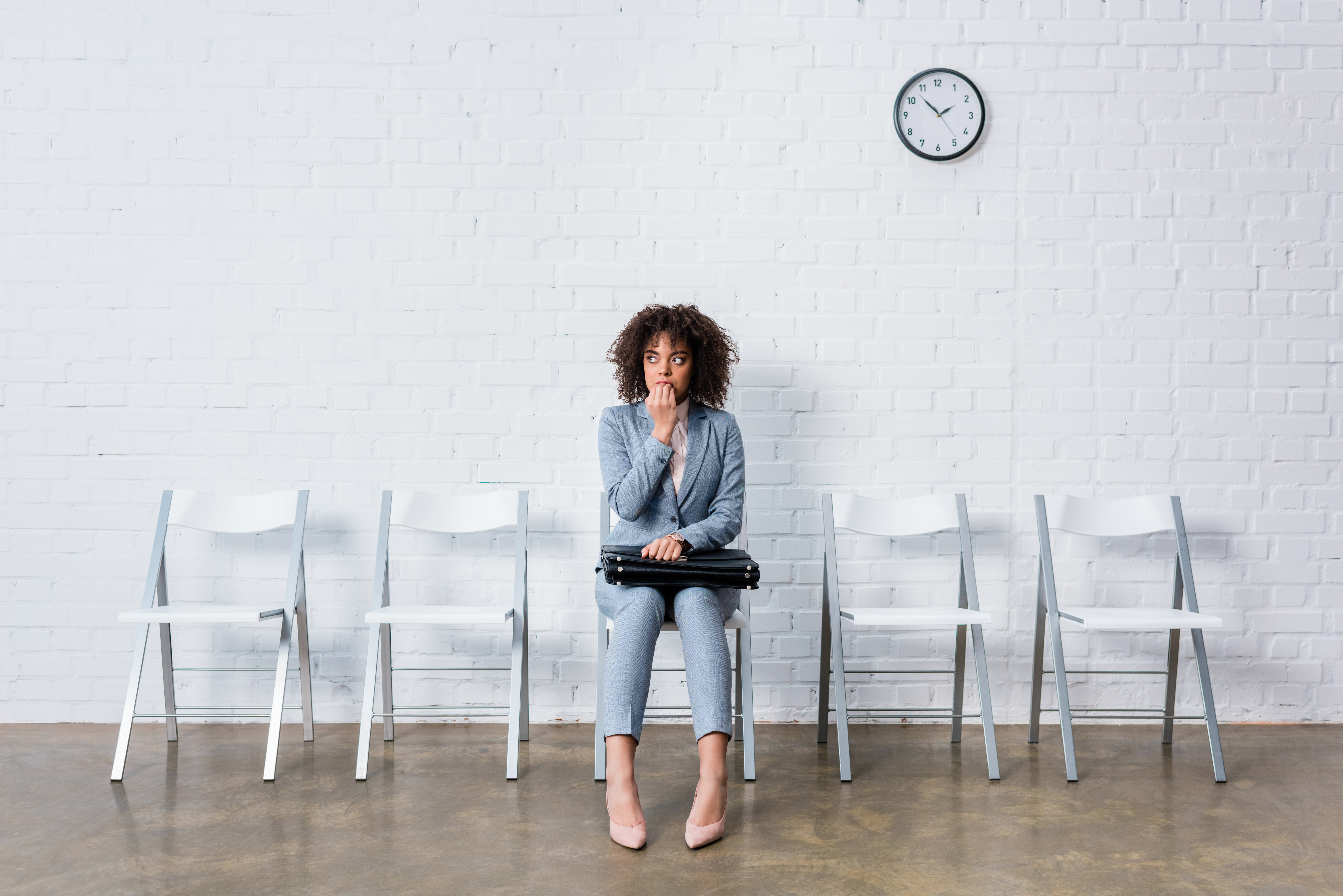 Woman sitting in white chair waiting alone