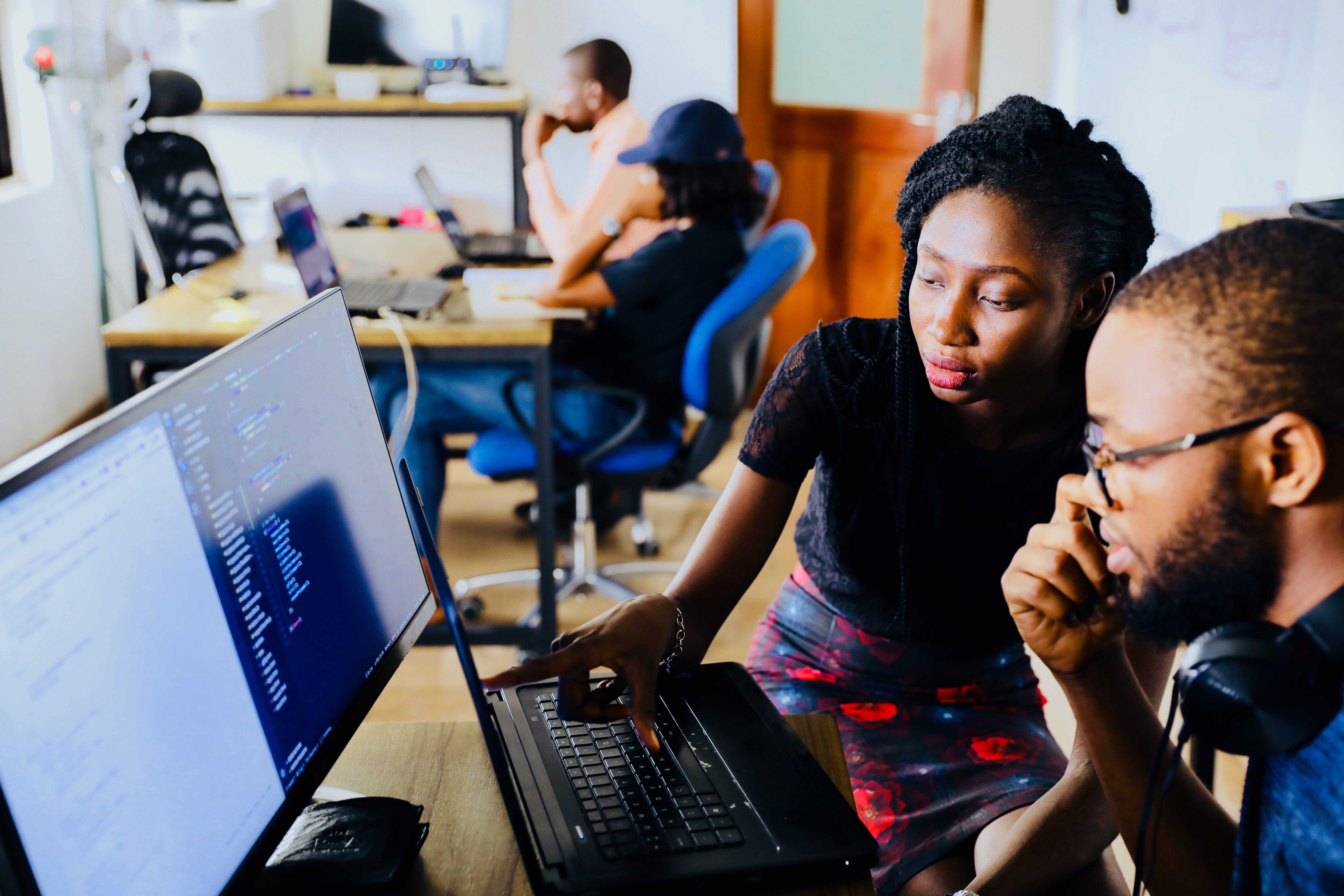 Two person looking and studying a computer screen