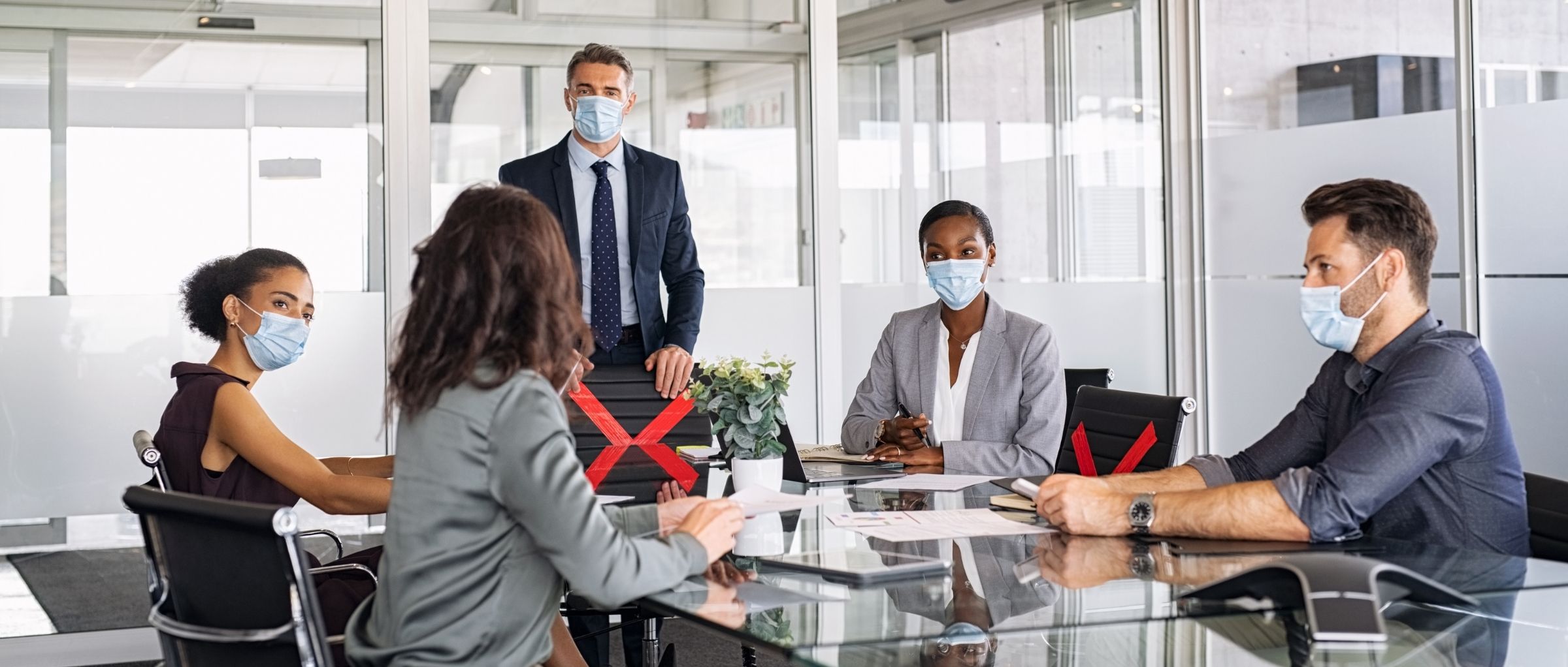 Group of professionals sitting a table weaing masks