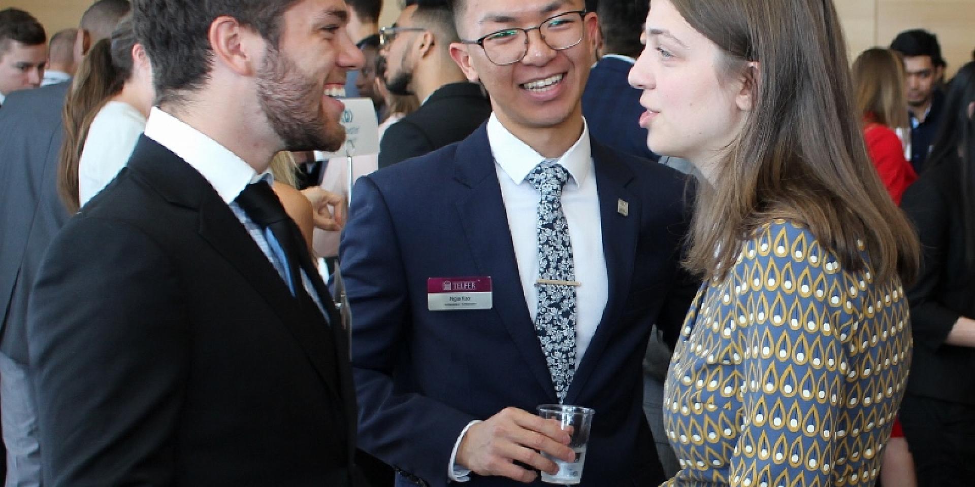 three professionals speaking together at an event