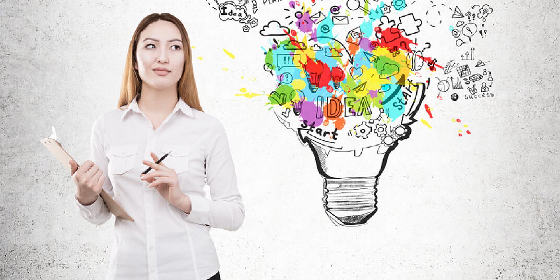 Woman standing in front of a wall with paint splatter and ideas