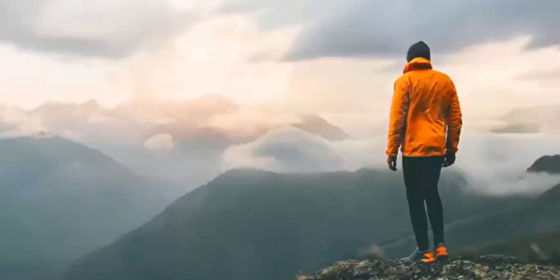 Person standing on top of a mountain