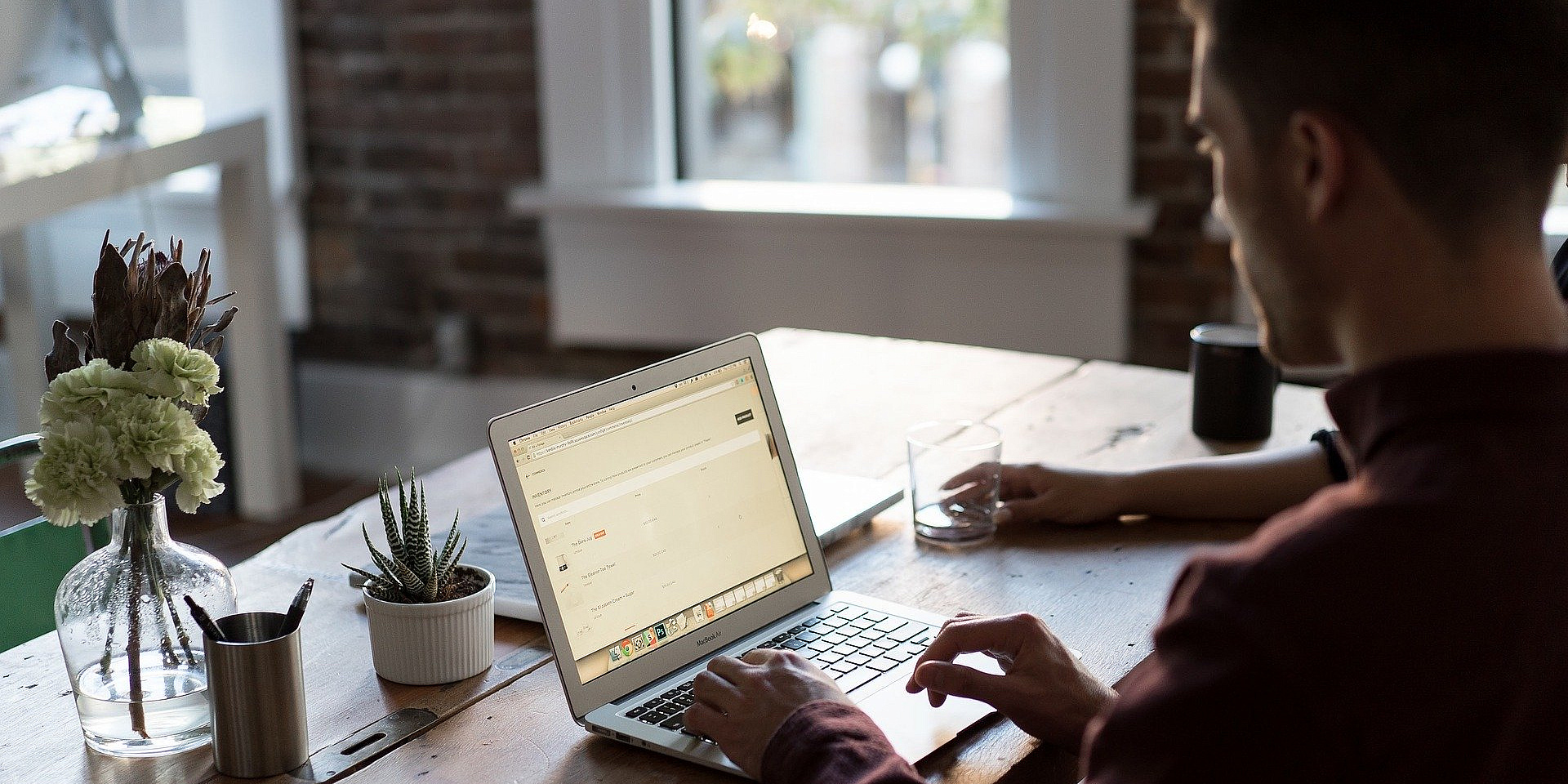 Man using laptop with plants on the table