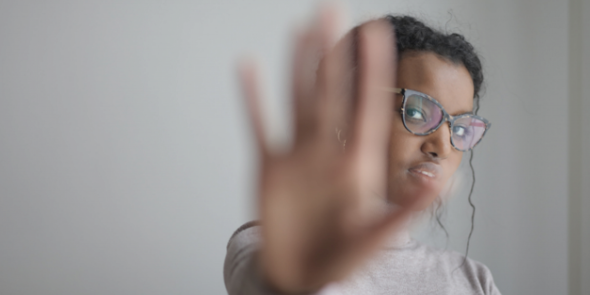 BIPOC women holding her hand up.