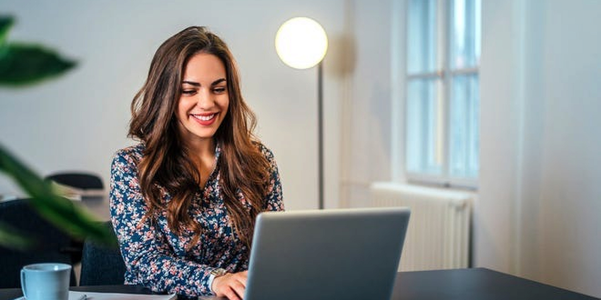 Femme qui utilise son ordinateur portable chez elle