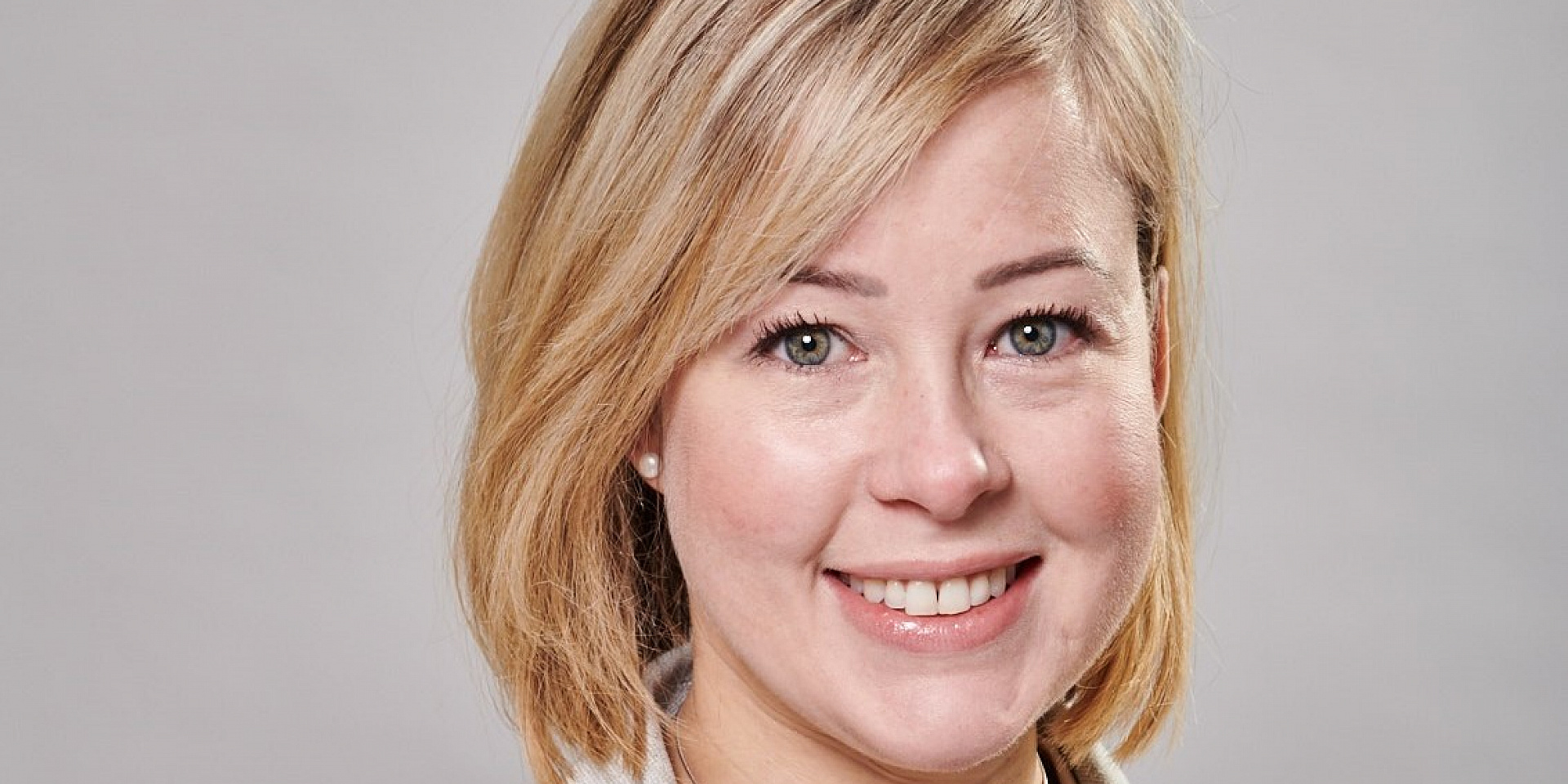 Véronique Bélinge smiling in front of a white background