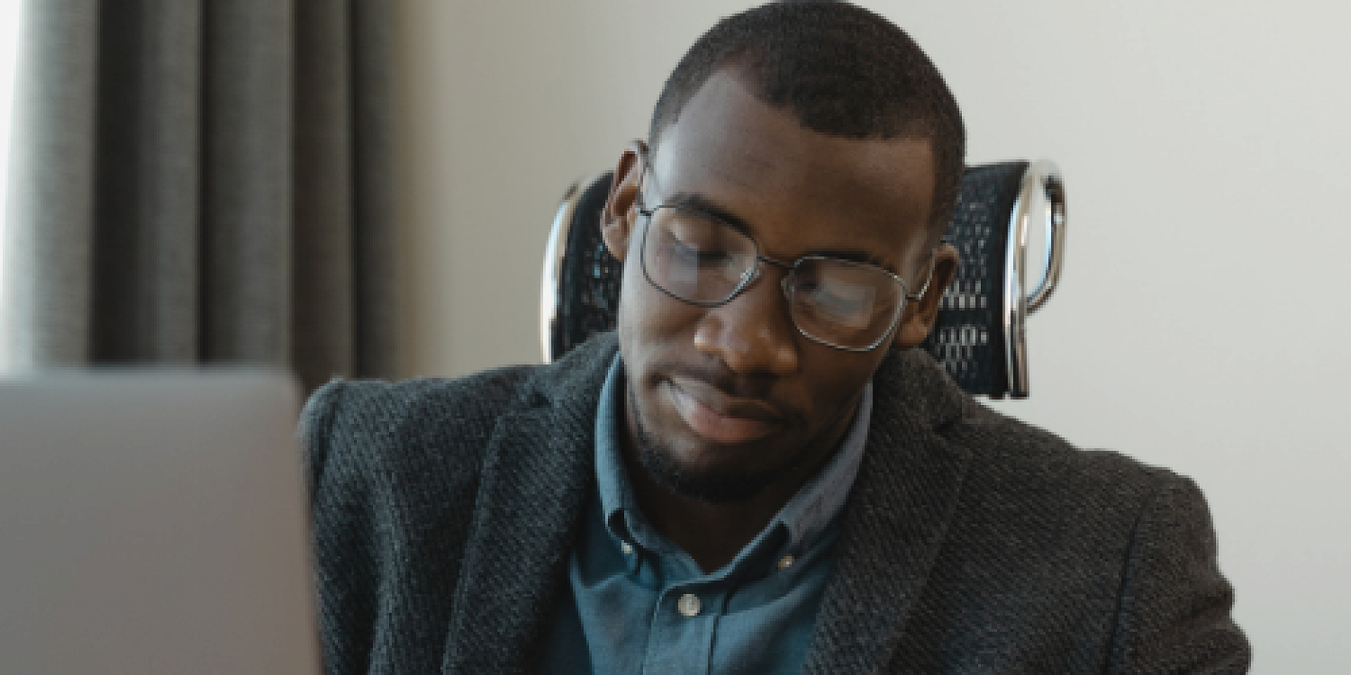 Man dressed professionally sitting at his desk.