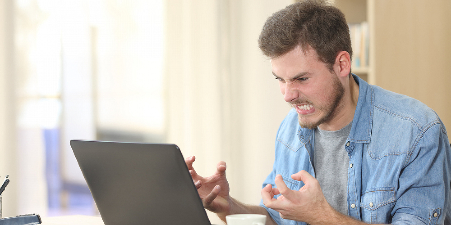 Homme frustré devant son ordinateur portable.