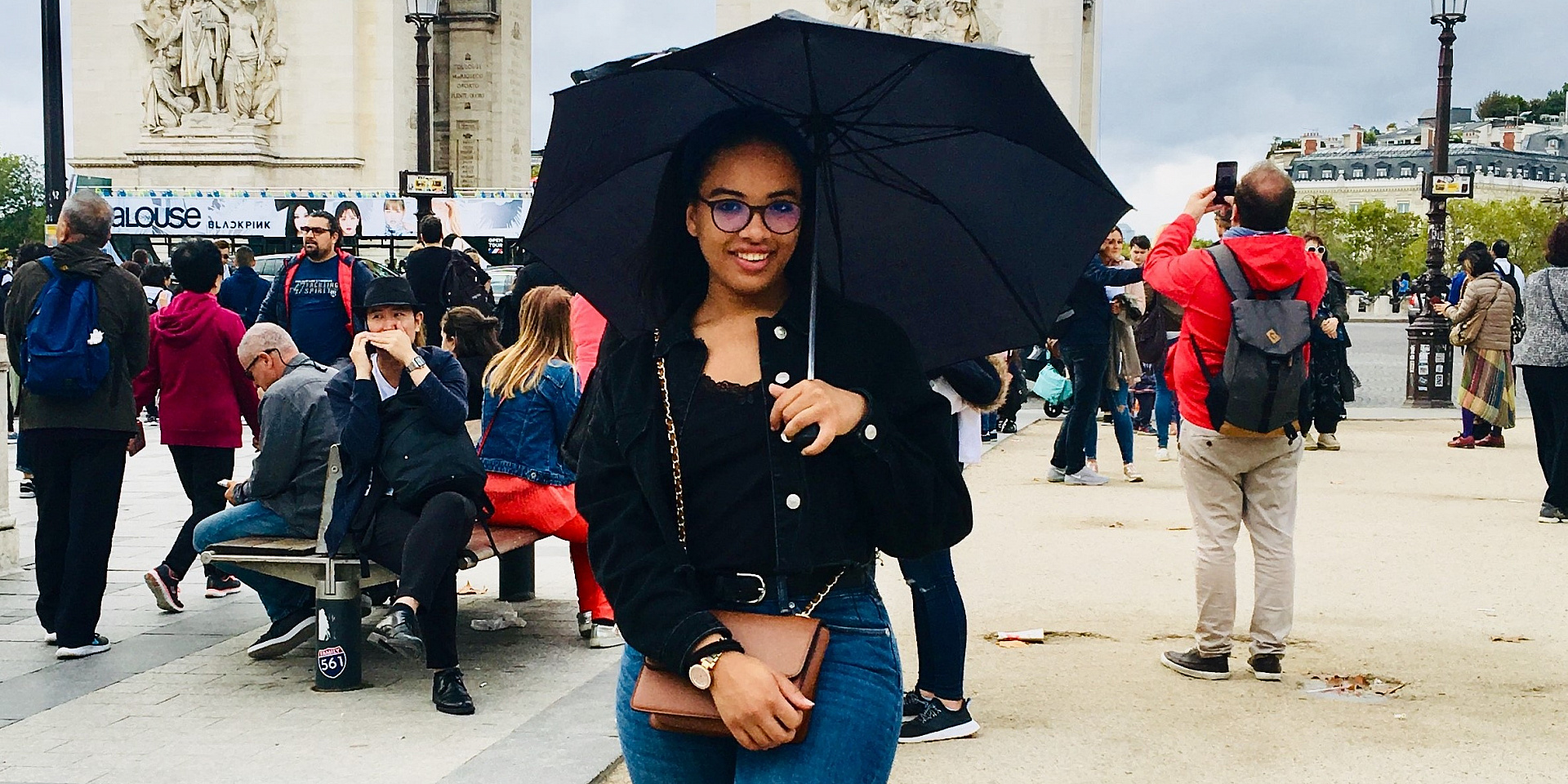 Ghita holding an umbrella in a public area.