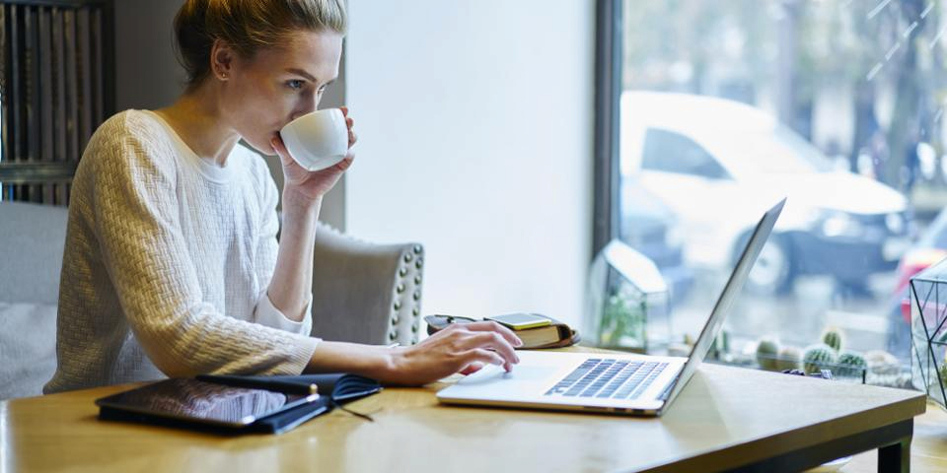 Student working on her laptop and drinking coffee.