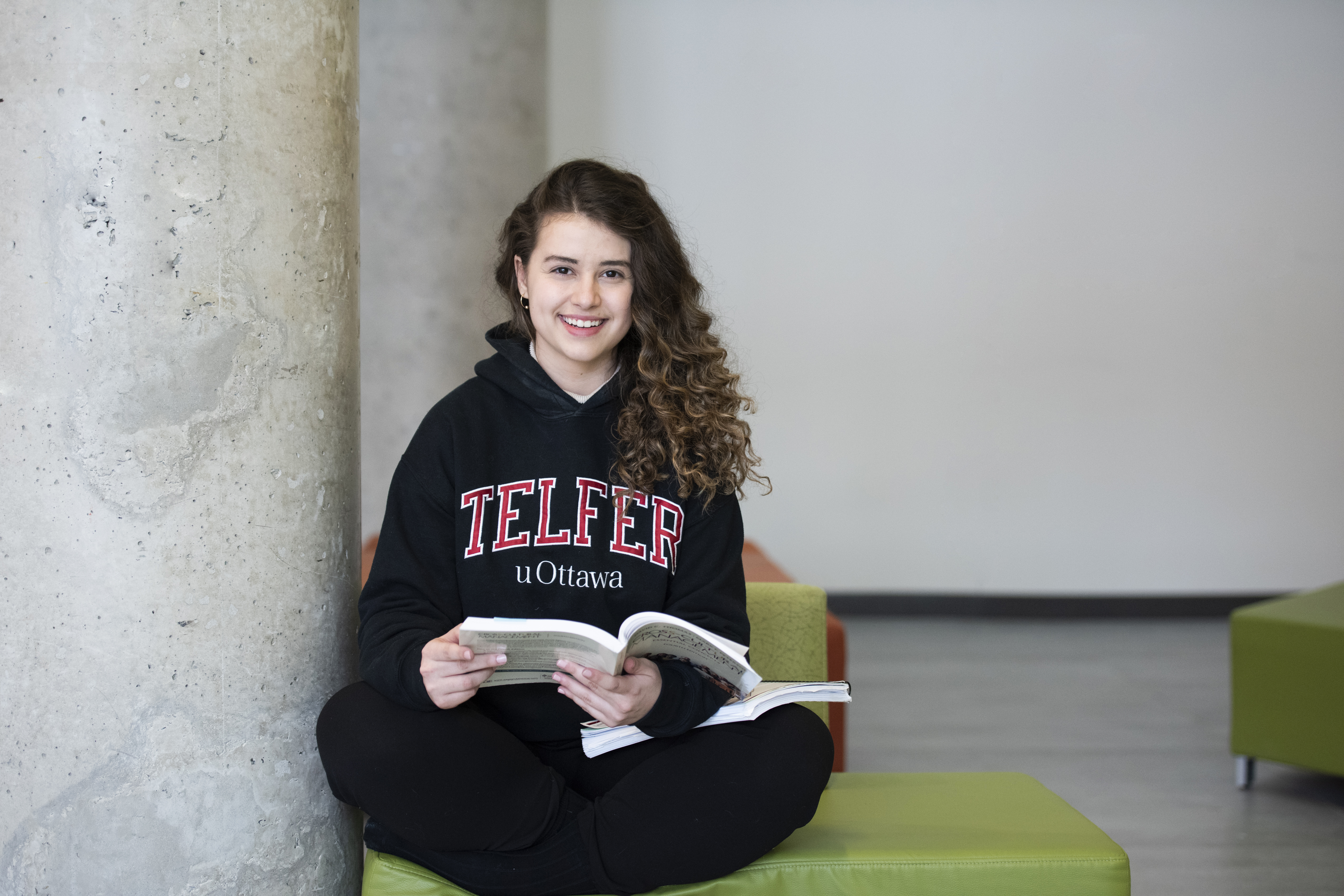 Smiling girl sitting on the floor with book