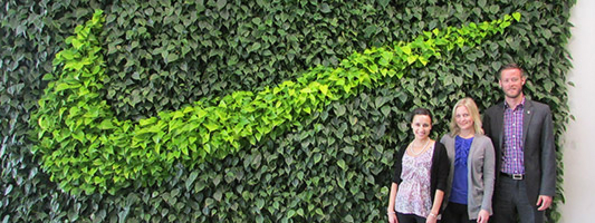 MBA students standing in front of a green wall Nike logo
