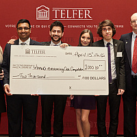 winners of the accounting capstone standing in front of a branded backdrop with their prize cheque.