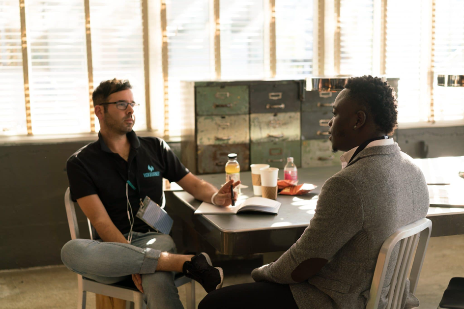 Two man talking while sitting around a conference table