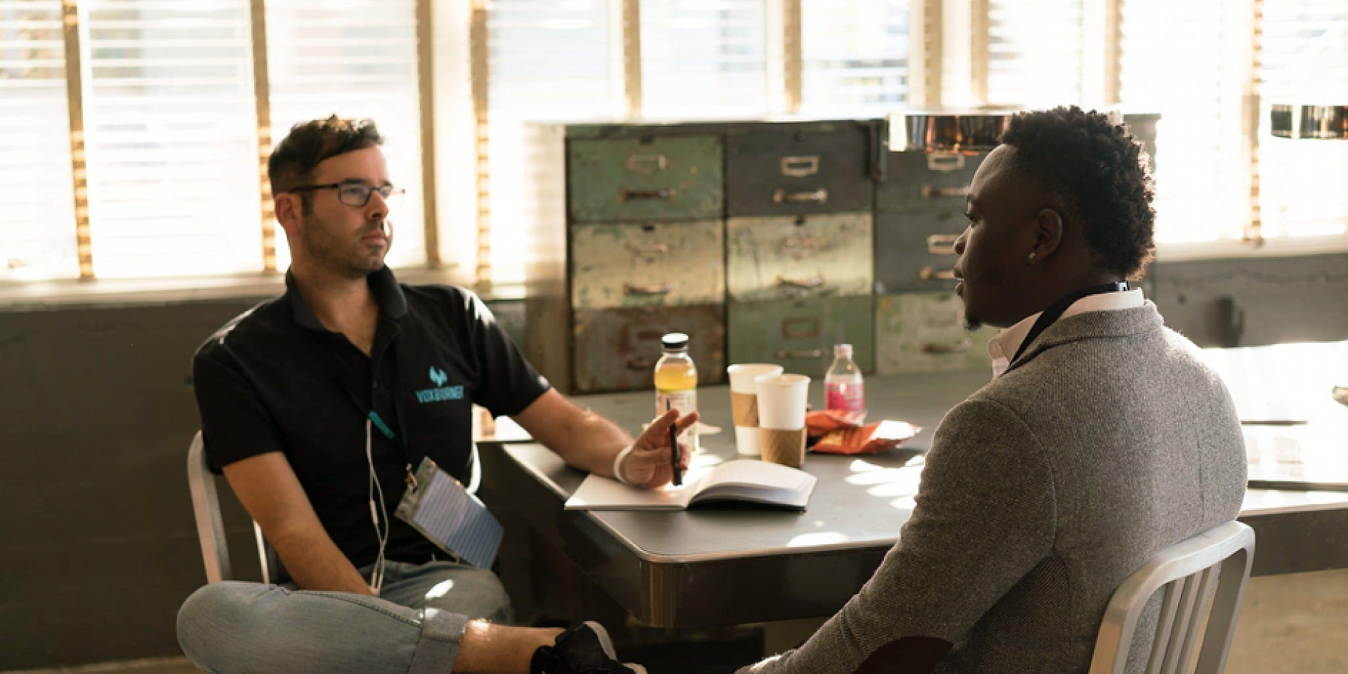 Two man talking while sitting around a conference table