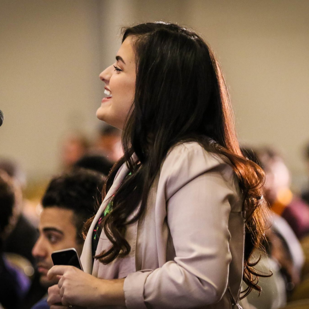 woman speaking on microphone at legacy conference