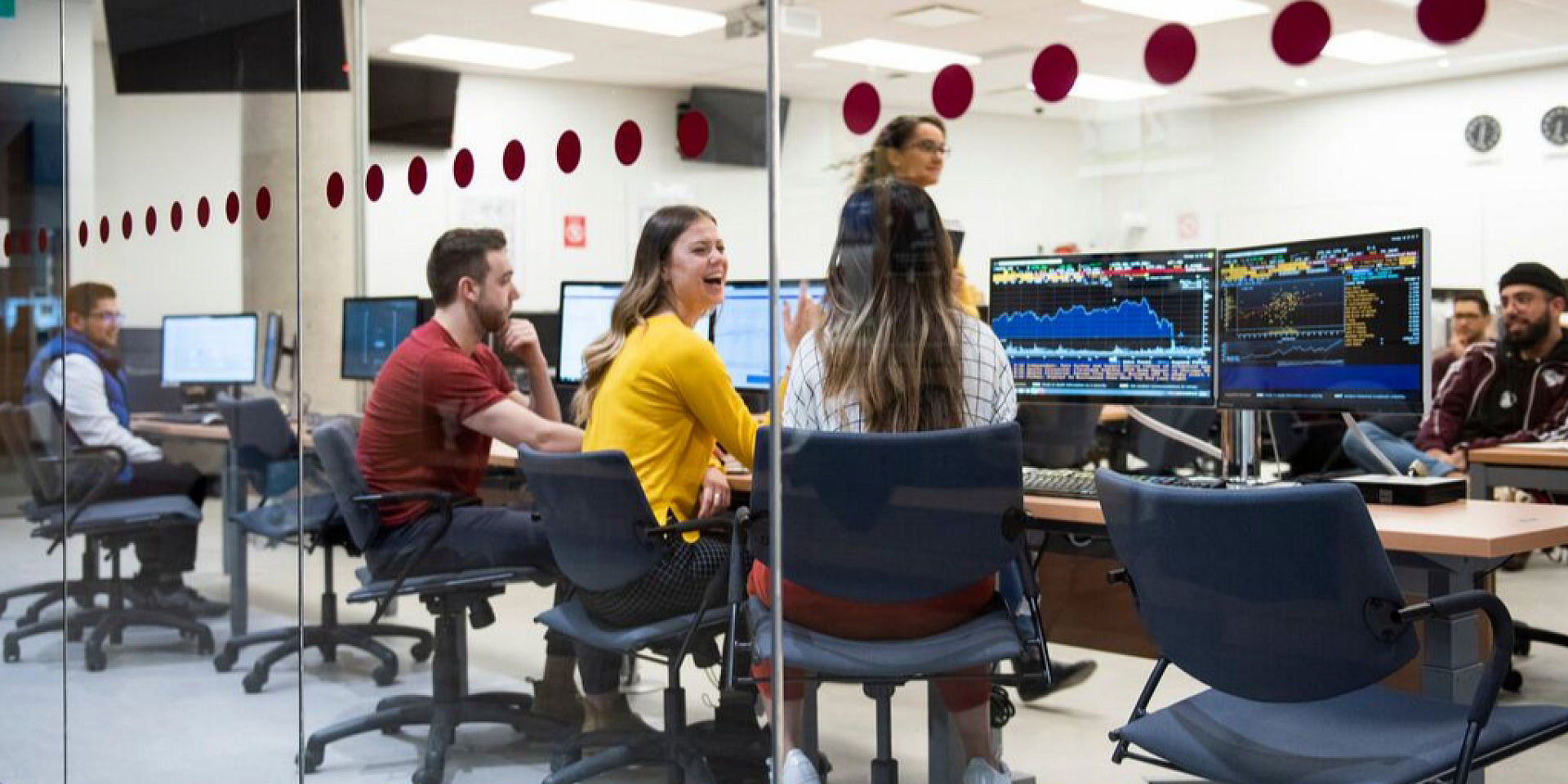 Students smiling in financial lab.