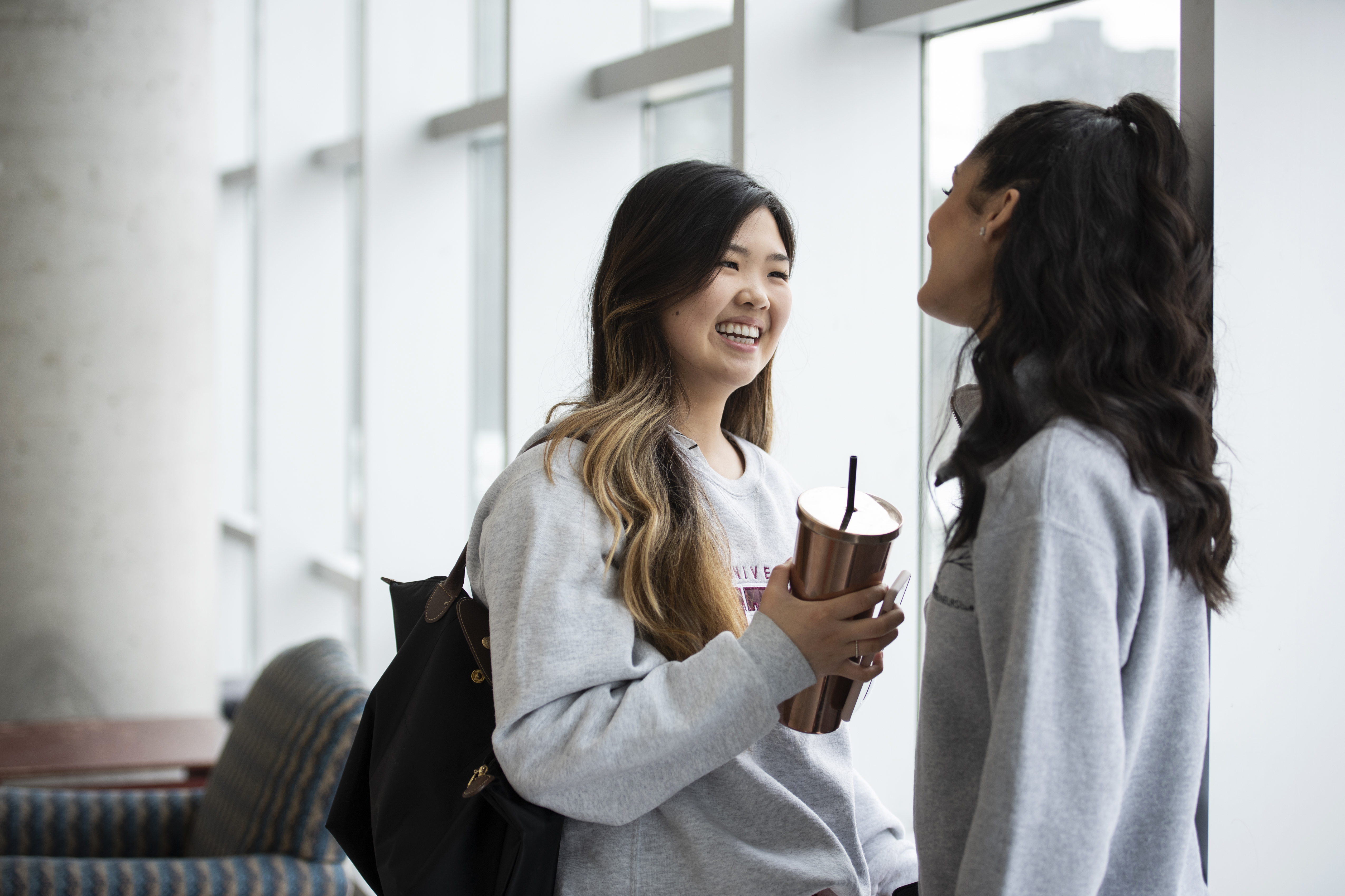 two students talking and smiling