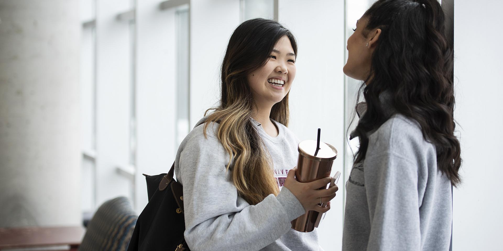 two students talking and smiling