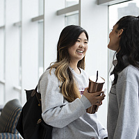 two students talking and smiling