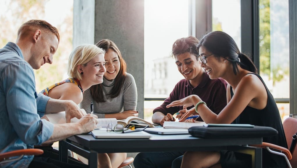 Group of students studying and laughing
