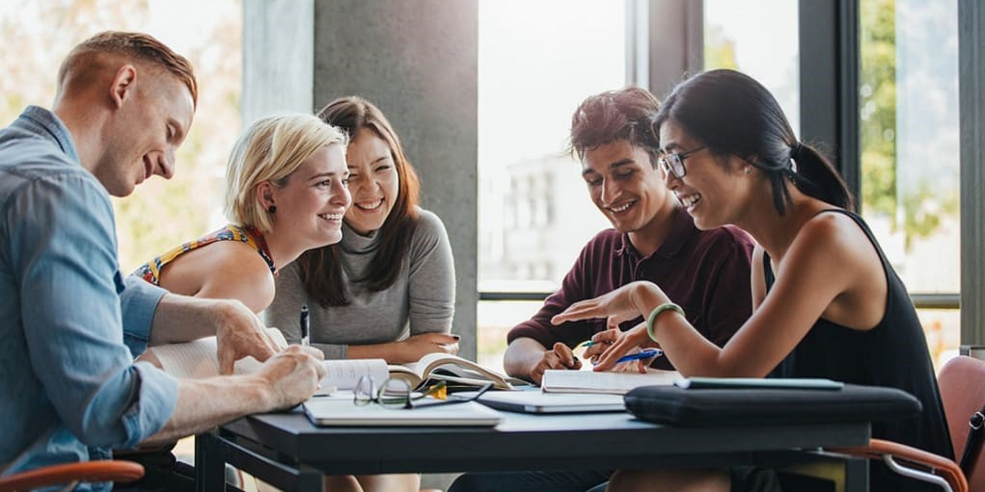 Group of students studying and laughing