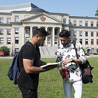 Telfer students studying on the Tabaret lawn with their textbooks
