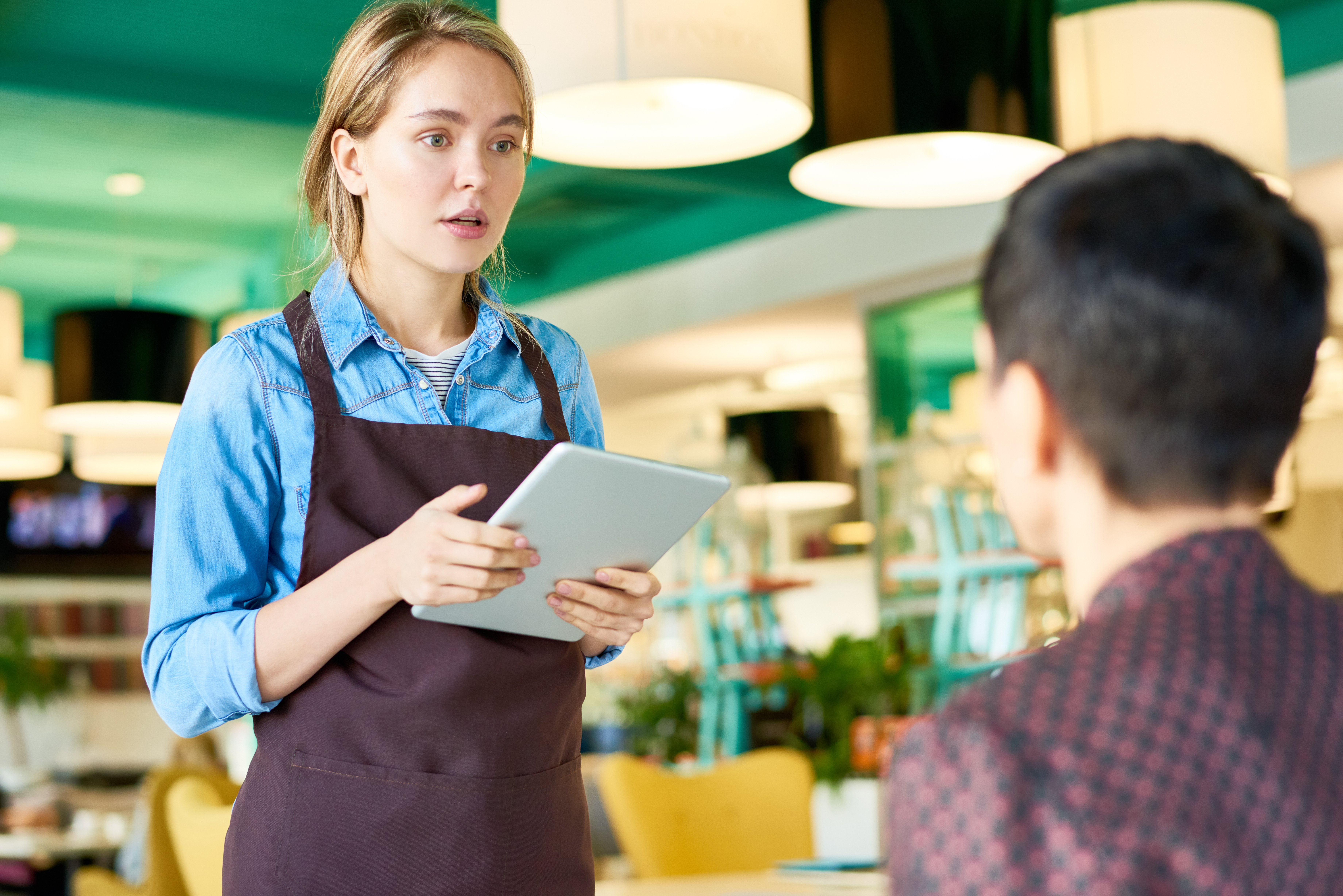 Young waitress taking orders in cafe