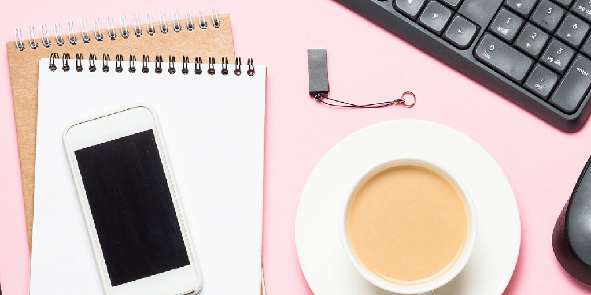 stylo, bloc-notes, téléphone, clavier et souris d'ordinateur sur le bureau