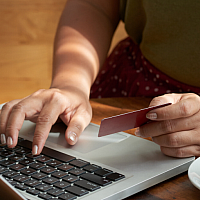 person shopping online holding credit card