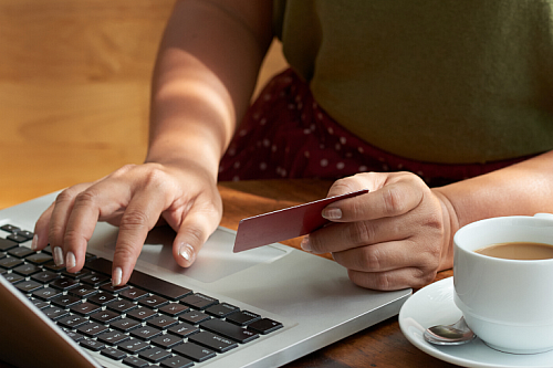 person shopping online holding credit card