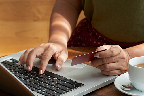 person shopping online holding credit card