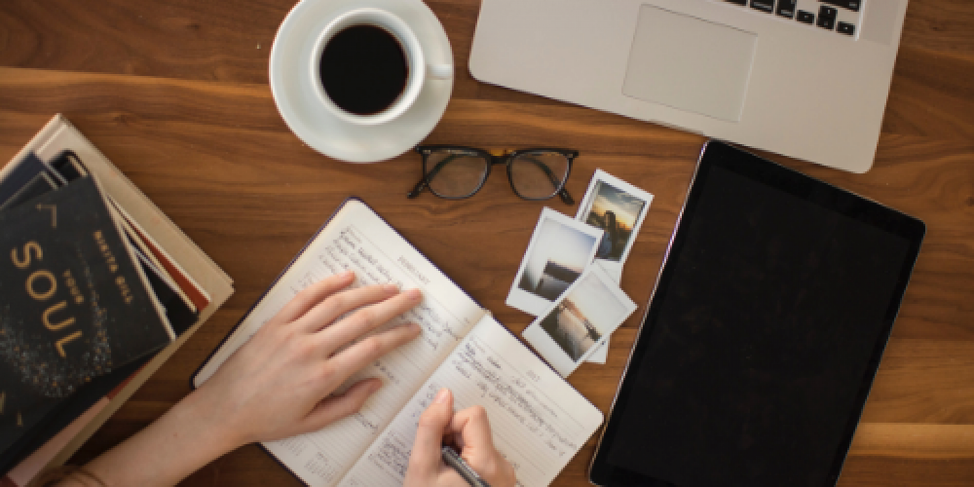 Table with a laptop, coffee mug, and tablet.