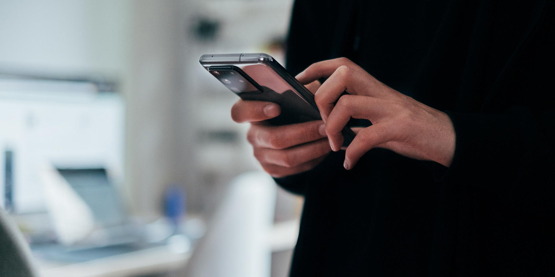 Des mains qui tiennent un téléphone cellulaire.