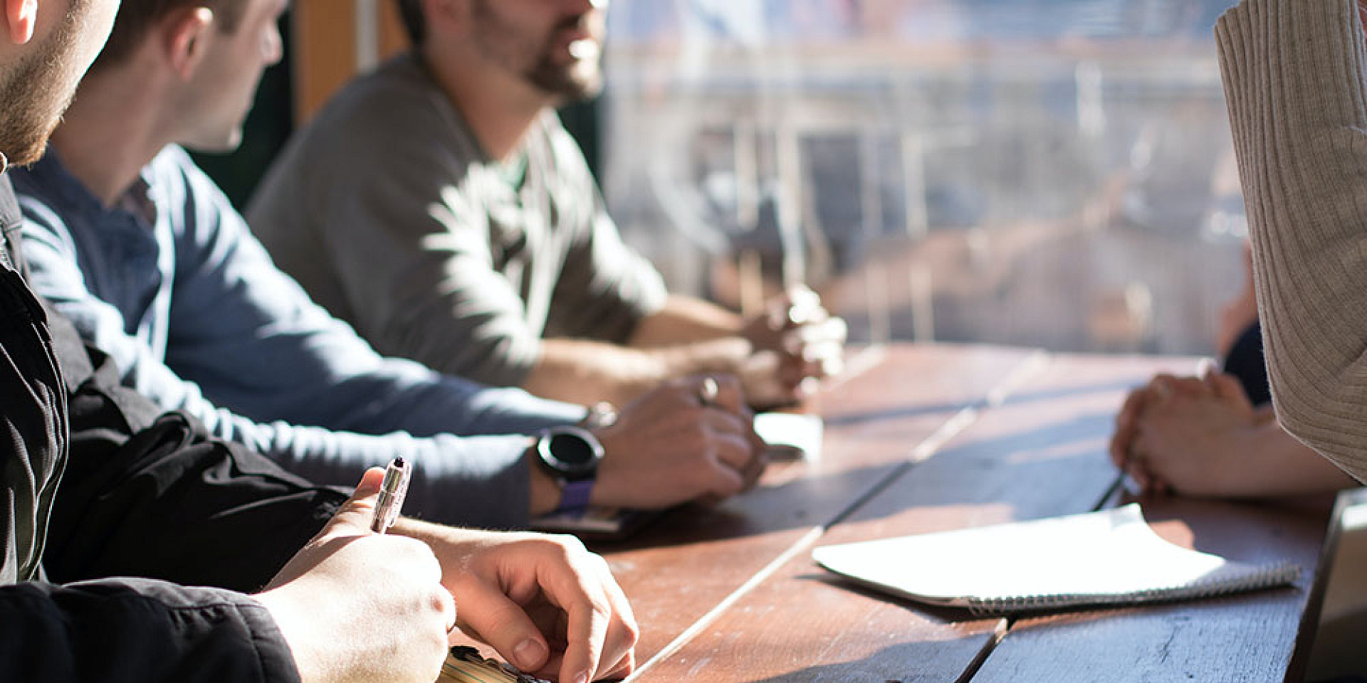 group of colleague discussing around a meeting table