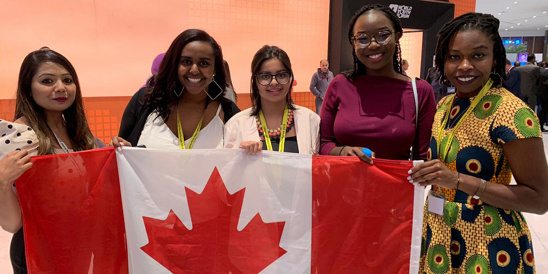 Gaëlle Faye with students holding a Canadian flag.