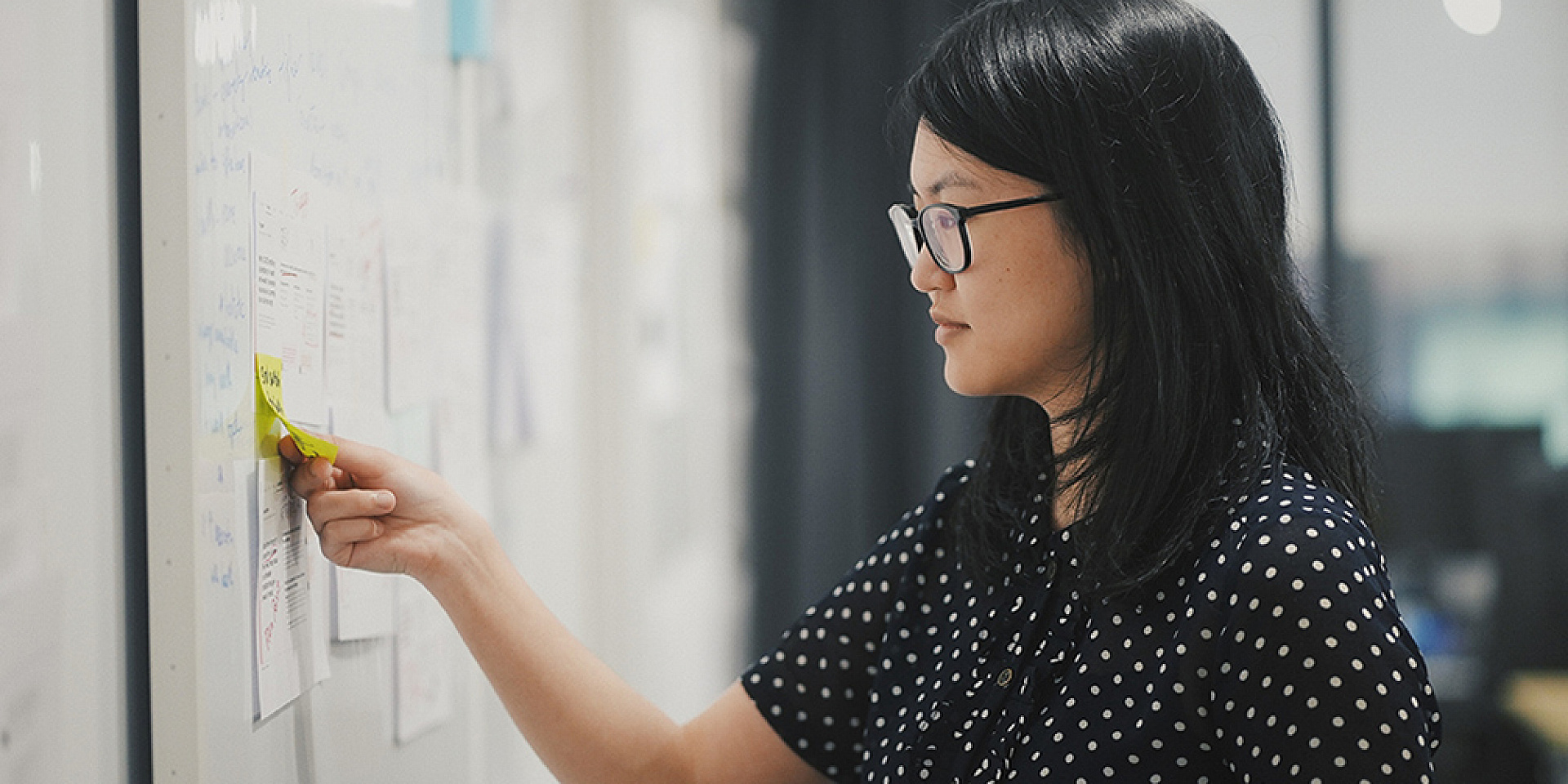 Asian worker writing on a whiteboard 