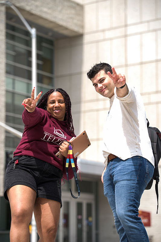 Two students in front of Desmarais Building