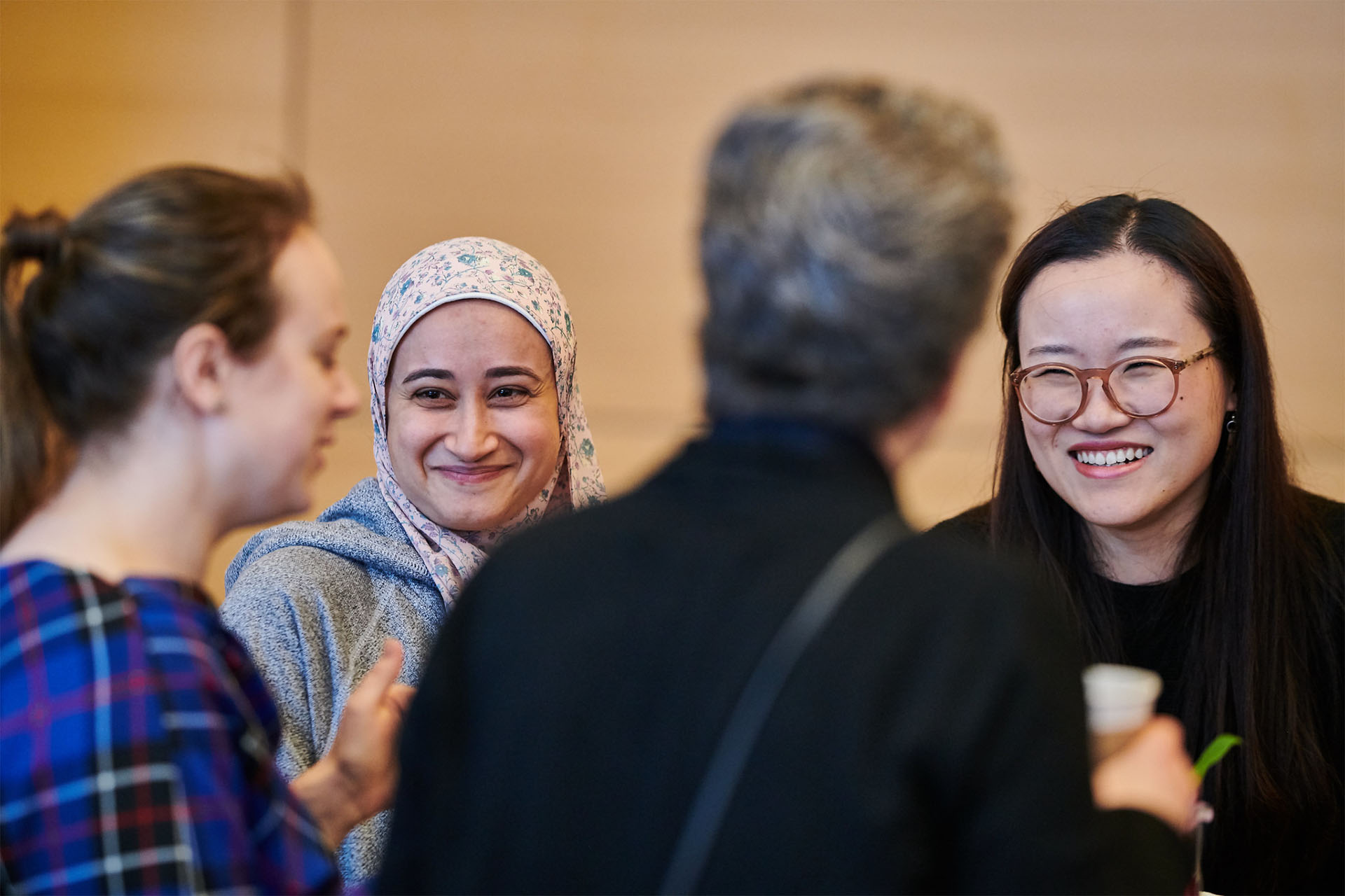 Two Telfer students, smiling and engaged in conversation with other event attendees.