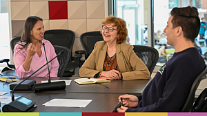 Three participants collaborate at a table at Telfer's Executive Campus.