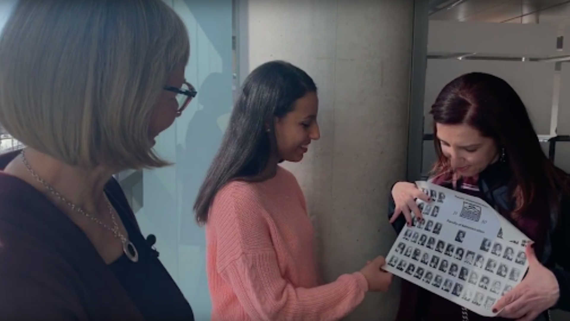 uOttawa alumna, student and professor looking at old graduating class photo