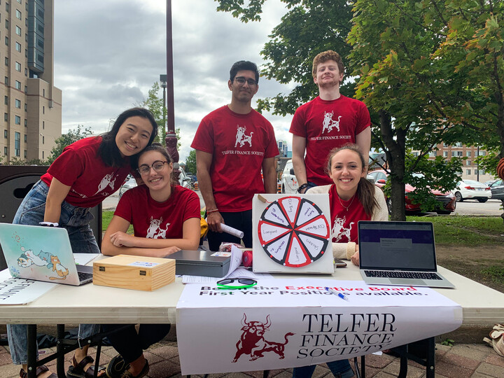 Étudiants de la Société de finance de Telfer derrière une table de présentation