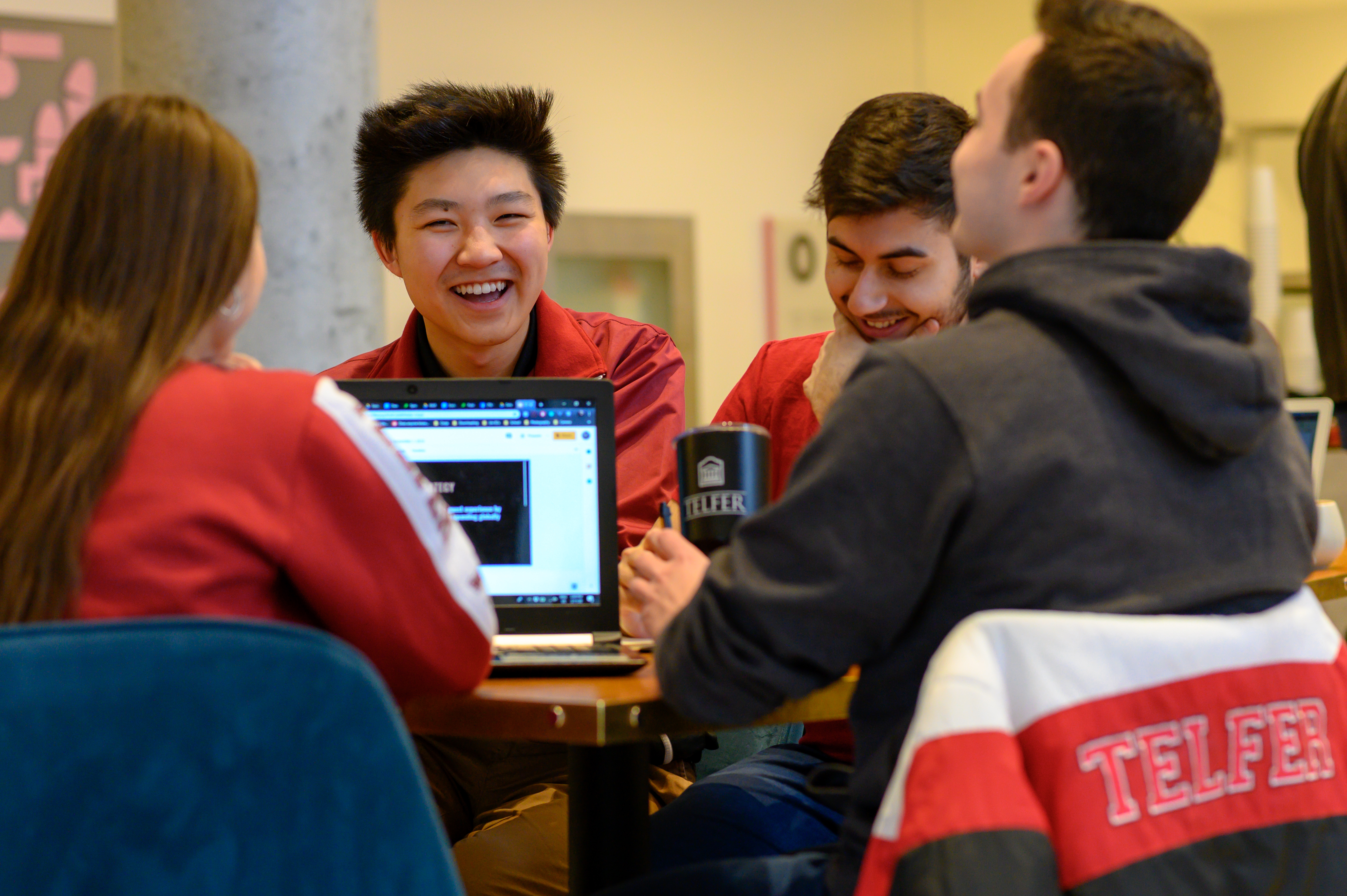 Groupe d'étudiants de Telfer qui sourient et étudient ensemble au pavillon Desmarais