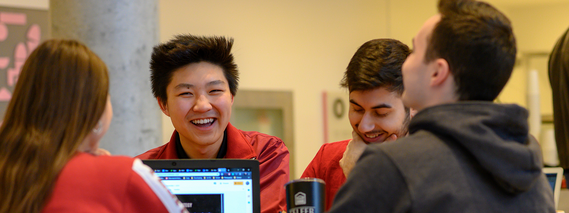 Groupe d'étudiants de Telfer qui sourient et étudient ensemble au pavillon Desmarais