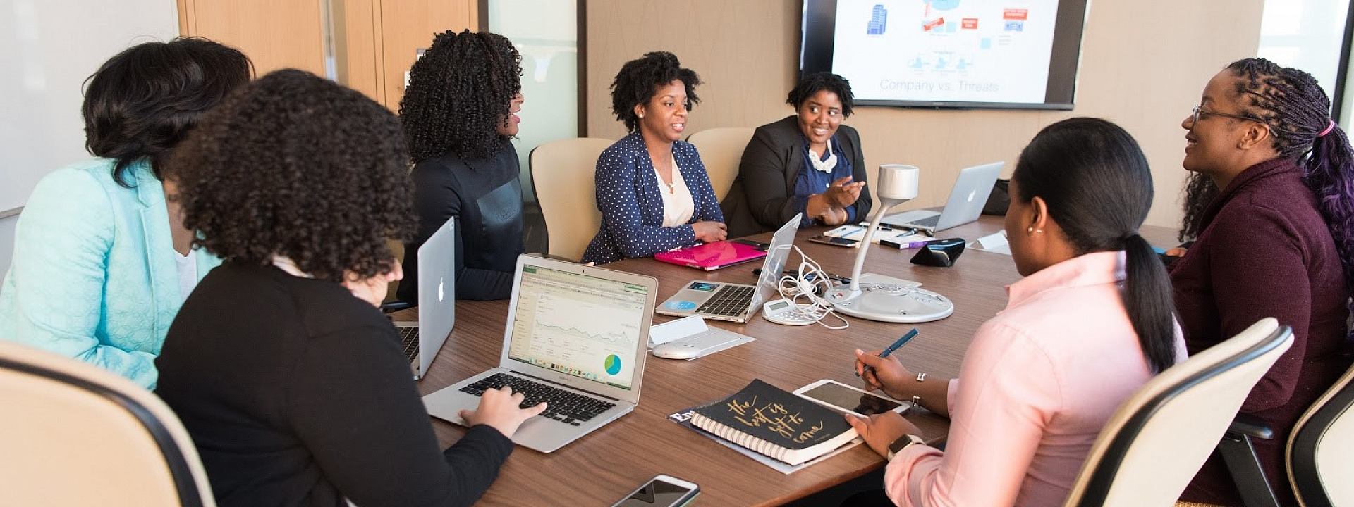 A group of women entrepreneur working and discussing around a conference table