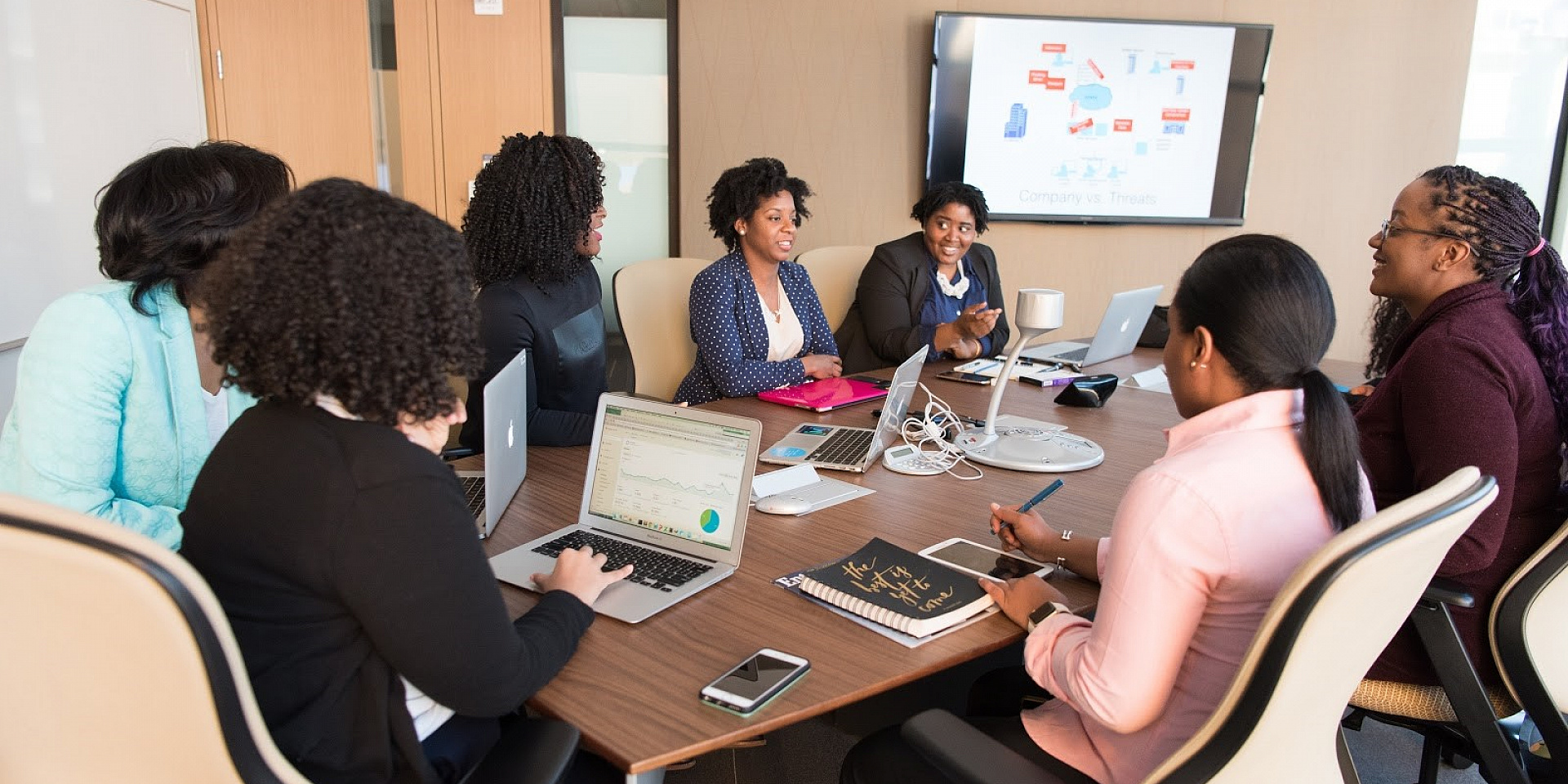 Plusieurs femmes entrepreneures discutent et travaillent autour d'une table de conférence