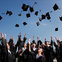 Étudiants lançant leur chapeau de diplômé en l'air par une journée d'été.