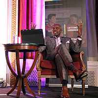 Wes Hall speaking on stage next to Dean Stephane Brutus at the Entrepreneur’s Club 31st annual Toast of Succes Dinner