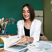 Smiling girl at a desk painting