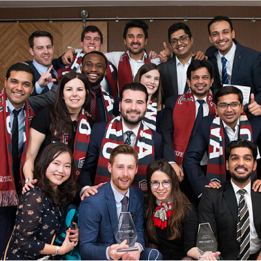 Des candidates et candidats au programme de MBA de Telfer sourient en exhibant des prix remportés aux jeux du MBA.